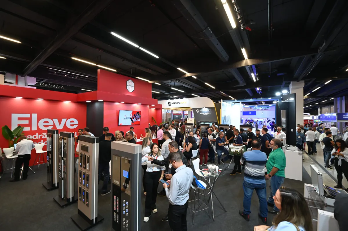 Pavilhão da feira com estandes e visitantes